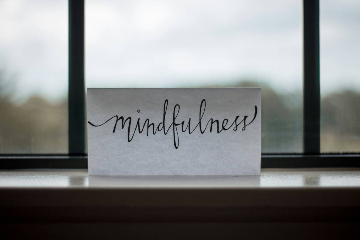 Woman practicing mindset change hypnosis while meditating in peaceful home setting