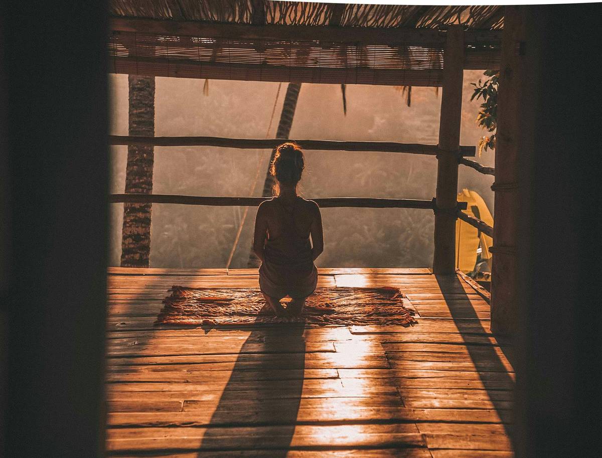 Woman listening to subconscious renew help audio while meditating peacefully at home
