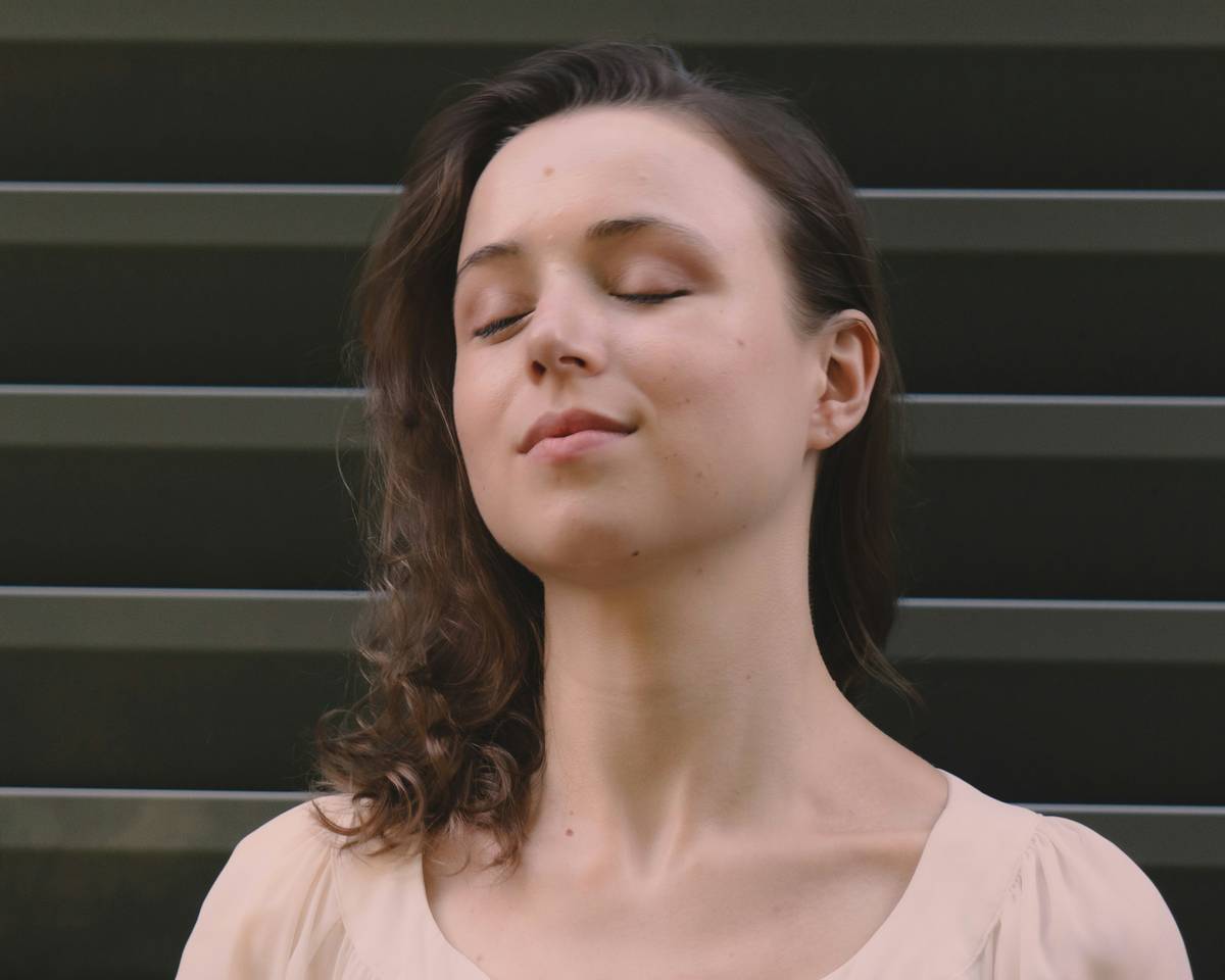 Woman relaxing during a calm hypnosis session with headphones and eyes closed